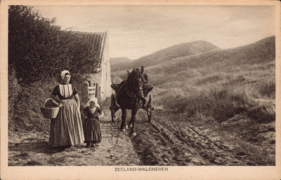 10886 Zeeland-Walcheren. Een vrouw en een meisje in Walcherse klederdracht en een boer op een kar bij een weg met een ...