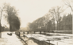 1932 Heerengracht. Gezicht op een besneeuwde Herengracht te Middelburg met boomstammen in het water