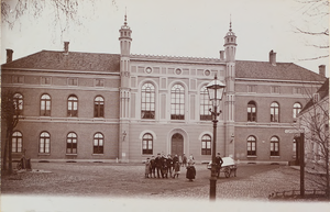 3829 Gezicht op de voorgevel van het Gasthuis aan het Noordpoortplein te Middelburg met poserende jeugd; rechts een wegwijzer