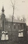 5100 Borsele. Gezicht op de Nederlandse Hervormde kerk in Borssele, met op de voorgrond vier vrouwen in dracht