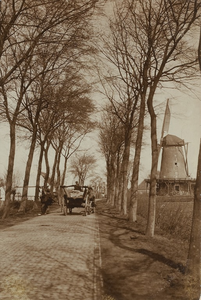 584 Twee elkaar passerende paard-en-wagens op de Noordweg te Sint Laurens met rechts de molen