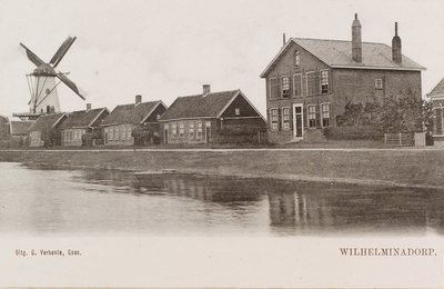 5880 Wilhelminadorp. Gezicht op huizen aan het Goese havenknaal en de korenmolen in Wilhelminadorp