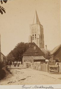 646 Toren - Oostkapelle. Gezicht op een straat in Oostkapelle met op de achtergrond de toren van de Ned. Herv. kerk