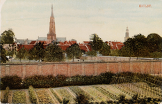 7587 Hulst. Gezicht op Hulst met de torens van de St. Willibrorduskerk en het stadhuis. Op de voorgrond een moestuin