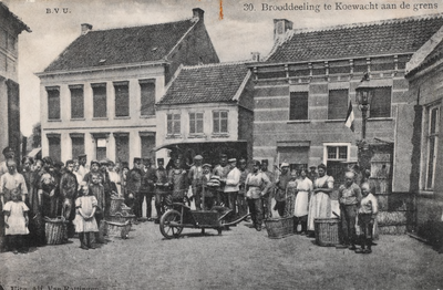 7719 Brooddeeling te Koewacht aan de grens. Een groep mensen tijdens de Eerste Wererldoorlog staat met manden te ...