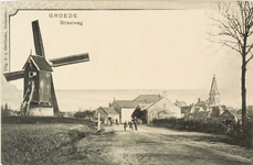 8345 Groede Straatweg. Gezicht op de straatweg bij Groede met links een molen en rechts de Ned. Herv. kerk
