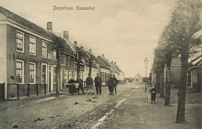 8379 Dorpstraat, Nieuwvliet. Poserende militairen en een vrouw in dracht met korven aan de arm in de Dorpstaat te Nieuwvliet