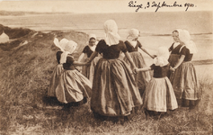 9245 Dancing on the sand-hills, Zeeland (Holland). Een groep meisjes in Walcherse dracht maakt een rondedans op de top ...