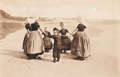 9247 Rondedans. Zeeland (Holland). Een groep kinderen in Walcherse dracht maakt een rondedans op het strand