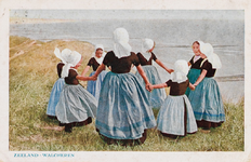 9254 Zeeland - Walcheren. Een groep meisjes in Walcherse dracht maakt een rondedans bovenop een duin