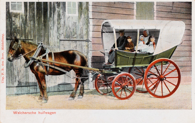 9259 Walchersche huifwagen. Een Walcherse verewagen met daarin een gezin in Walcherse dracht voor een boerenschuur