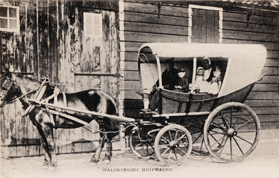 9267 Walchersche huifwagen. Een Walcherse verewagen met daarin een gezin in Walcherse dracht voor een boerenschuur