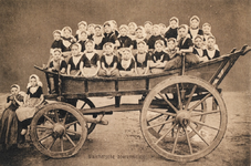 9283 Walchersche boerenmeisjes. Een groep meisjes in Walcherse dracht op een Walcherse boerenwagen