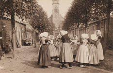9311 Ronde joyeuse. Een aantal meisjes in de Kerkstraat te Nieuwland in een rondedans. Op de achtergrond de Ned. Herv. kerk