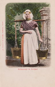 9320 Melkmeisje in Zeeland. Een meisje bij een hek, met juk en koperen emmers in protestantse, Zuid-Bevelandse dracht