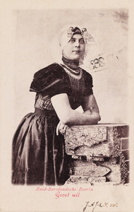 9325 Zuid-Bevelandsche Boerin Groet uit. Een vrouw in protestantse, Zuid-Bevelandse dracht, leunend op een muurtje