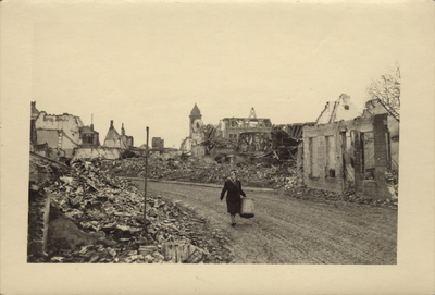 291-1 Brouwerijstraat. Een vrouw met mand in de verwoeste Brouwerijstraat te Oostburg na de bevrijding door de geallieerden