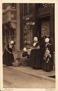 320-238 Enkele vrouwen en meisjes in dracht voor de winkel in koloniale waren van M. van Boven aan de Pottenmarkt K 410 ...