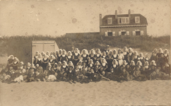 341-706 Poserende groep meisjes in klederdracht op het strand te Domburg
