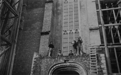 351-67 Bouwvakkers boven de toegangsdeur van de Koorkerk te Middelburg tijdens de wederopbouw