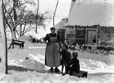 40-6B Een boerin en twee kinderen op een besneeuwd boerenerf in Zeeland