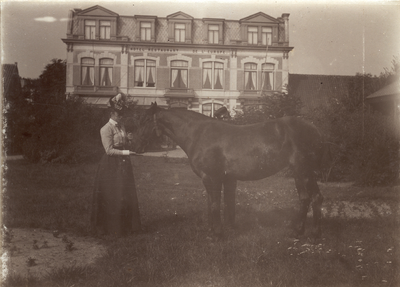 425-9 Gezicht op het hotel de l' Europe aan de Noordstraat te Domburg, met op de voorgrond een dame met een paard in de tuin