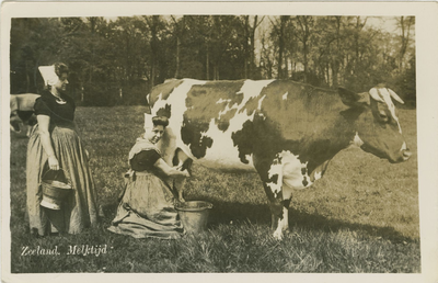 455-1293 Zeeland. Melktijd. Twee vrouwen in dracht bezig met het melken van een koe