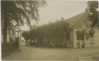 455-660 Koudekerke Dorpsplein. Personen in dracht voor een kruidenierswinkel op het Dorpsplein te Koudekerke
