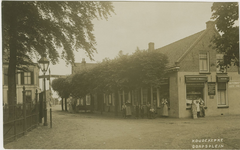 455-660 Koudekerke Dorpsplein. Personen in dracht voor een kruidenierswinkel op het Dorpsplein te Koudekerke
