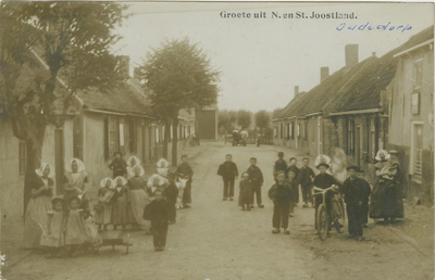 455-708 Groete uit N. en St. Joostland.. Personen in dracht in een straat te Nieuw- en Sint Joosland