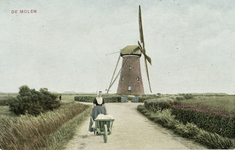 600-113 De molen. Een vrouw in dracht met een kruiwagen bij de molen Buiten Verwachting te Nieuw en Sint Joosland