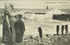 624-207 West-Kapelle - Woeste Zee. Een vrouw en jongetje in dracht op de dijk te Westkapelle bij stormachtig weer. De ...