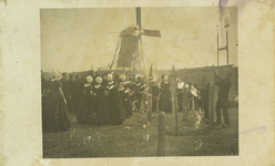 624-211 Mensen in dracht tijdens het gaaischieten te Westkapelle, met op de achtergrond de molen Prins Hendrik op de dijk