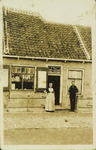 624-237 P. Houmes en echtgenote in Walcherse dracht voor hun schoen- en zadelmakerij / barbierwinkel te Westkapelle