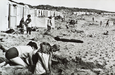 624-383 Westkapelle, Strandgezicht. Spelende kinderen op het strand te Westkapelle; tegen de duinen een rij cabines