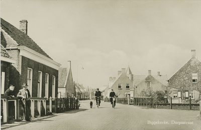 94-38 Biggekerke, Dorpsstraat. Gezicht op de Dorpsstraat te Biggekerke. De twee mannen links zijn v.l.n.r. Lou Verhage ...