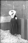 113-4 Een vrouw in Zuid-Bevelandse dracht voor de kade van de haven van Bruinisse