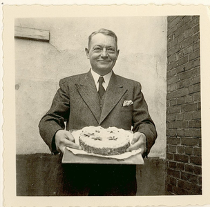 92-3 [3]. Dhr. De Greef toont de taart bij zijn afscheid van de Artillerie Inrichtingen Hembrug te Amsterdam, 14 okt. 1941