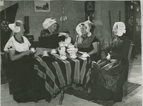 187-1 Vrouwen in dracht rond een tafel. V.l.n.r. Walcherse klederdracht, Schouwen dorpse dracht, Oud Zuid-Bevelandse ...