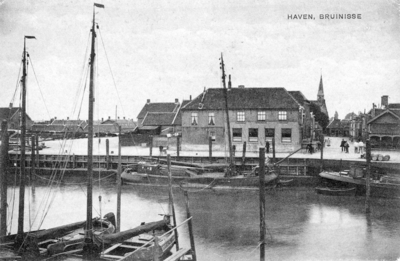 B-0736 Bruinisse. Het Veerhuis, met daarnaast de Oudestraat. Aan de haven en de loswal links een Tjalkschip met het ...