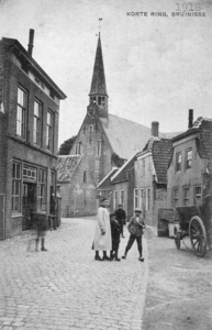 B-1578 Bruinisse. Korte Ring met Kerkplein. Rechts de wagenmakerij van Jan Krijger. De woningen rechts zijn van de ...