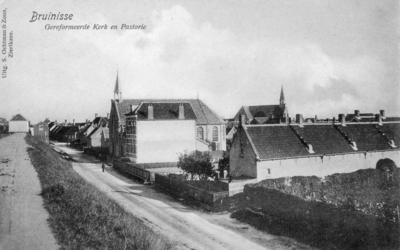 B-1642 Bruinisse. Noorddijk. De Ger. Kerk en pastorie, rechts op de achtergrond is de Ned. Herv. Kerk ook zichtbaar