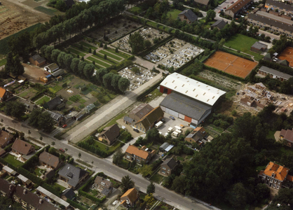 BRU-2498 Bruinisse. Op de voorgrond de Dorpsweg, met haaks erop de toegang tot de oude begraafplaats. Rechts de ...