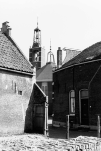 D-0237 Ouwerkerk. Op de achtergrond de nieuwe toren en kerk. Op de voorgrond links de zijmuur van de woning Zuidstraat ...