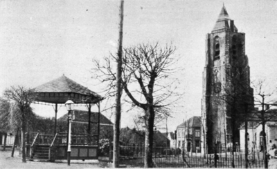 D-0719 Nieuwerkerk. Kerkring. Rechts de toren van de NH Kerk. Links daarvan de ingang van de Weststraat, en geheel ...