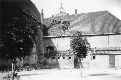 D-0814 Ouwerkerk. Ring. De lagere school, gezien van de achterzijde, en het koor van de kerk ernaast. Windhoos van 23 ...