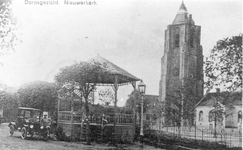 D-0939 Nieuwerkerk. Kerkring met de muziektent; naast de toren de openbare lagere school.