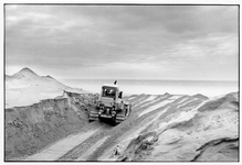 KZN-1585 Neeltje Jans. Bulldozers maken een verbinding tussen de zee en het binnenduin op Neeltje Jans waar een slufter ...