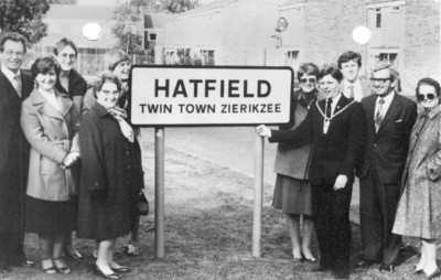 SW-1353 Hatfield. Jumelage met Hatfield. Plaatsnaambord in Engeland. v.l.n.r. Eddie Parker, Val Aschwell, Ann Fitts, ...