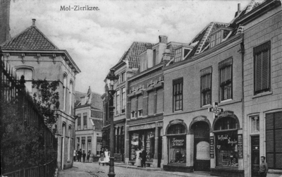 ZS-0879 Zierikzee. Mol. V.l.n.r: de tabaks- en sigarenwinkel van Arie Arnold, de kledingzaak van E. Kohschulte, het ...